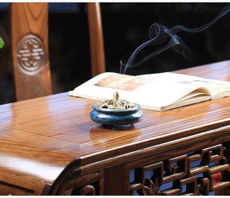 Blue and gold incense burner on a wooden table